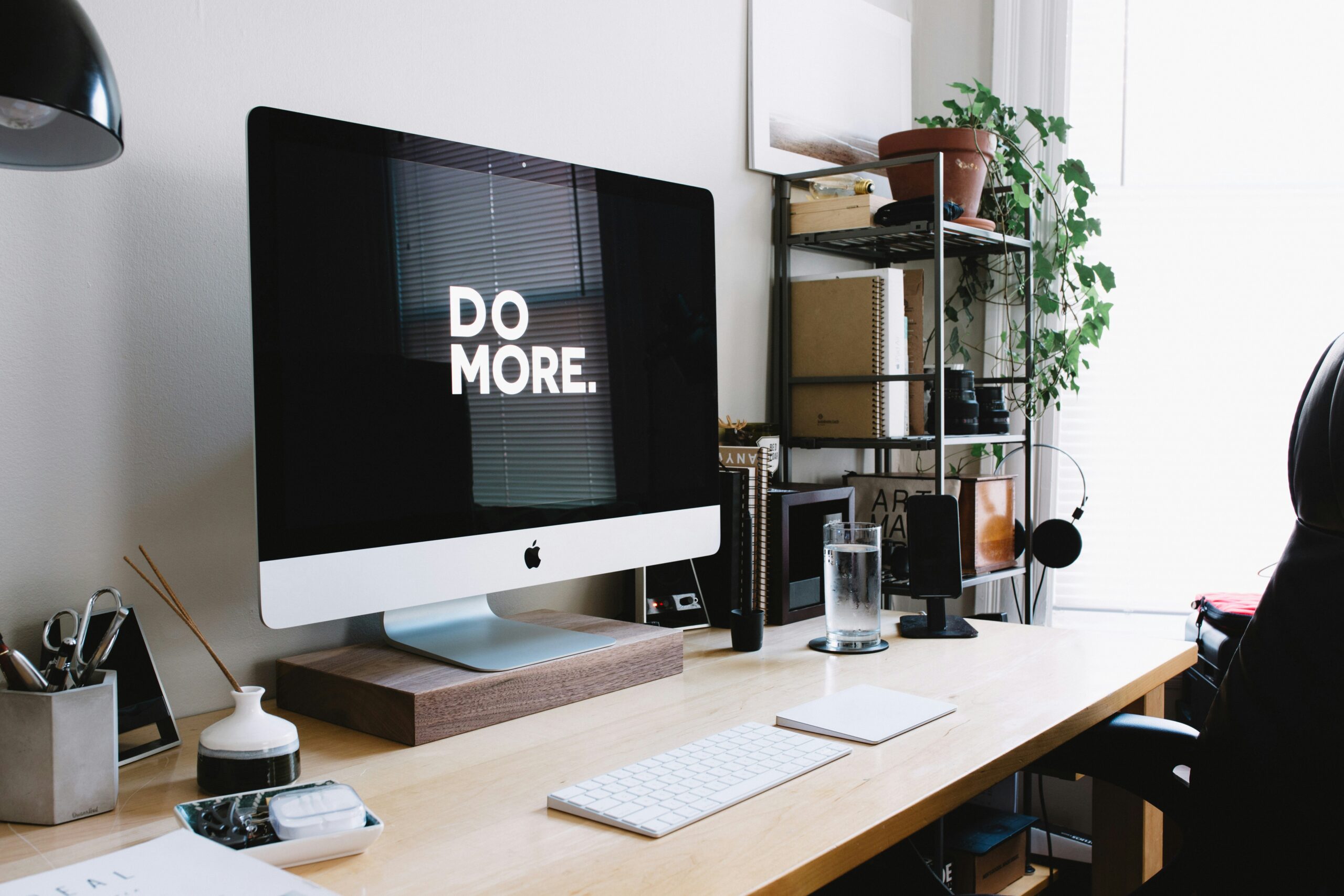 Modern home office with an iMac displaying “Do More,” symbolizing entrepreneurial motivation and the DIY website building mindset.